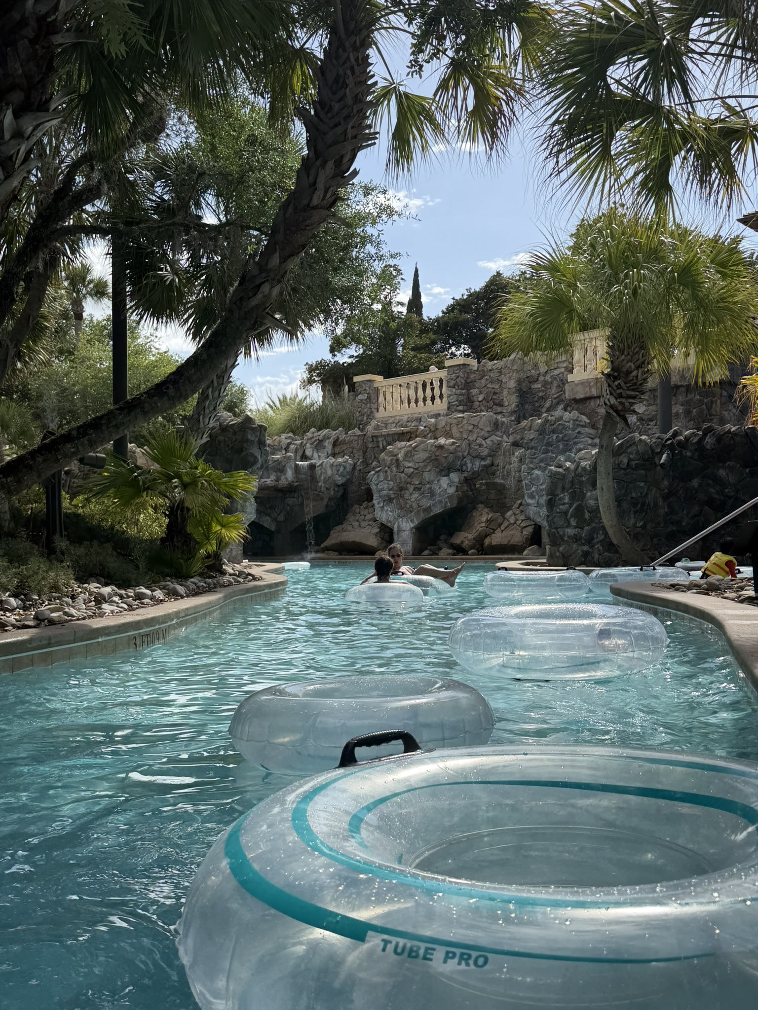 Guests floating the lazy river in tubes past rock formations